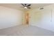 Bright bedroom with ceiling fan, sliding door closet, carpeted floor, and an entry door at 695 W Estrella Dr, Gilbert, AZ 85233