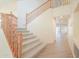 Grand carpeted staircase with wood railing, leads to the second floor, and offers view of entrance at 695 W Estrella Dr, Gilbert, AZ 85233