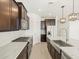 Modern kitchen featuring stainless steel appliances, granite countertops, dark wood cabinets, and a stylish kitchen island with a sink at 16073 W Cottontail Ln, Surprise, AZ 85387