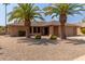 Ranch style home with desert landscaping and two palm trees in the front yard at 13223 W Jubilee Dr, Sun City West, AZ 85375