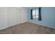 Bright bedroom with a blue accent wall, plush carpeting, and a window with dark curtains at 3801 E Captain Dreyfus Ave, Phoenix, AZ 85032