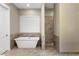Bright bathroom with a freestanding tub, tile floors, and walk-in shower with neutral tile surround at 19575 E Vallejo St, Queen Creek, AZ 85142