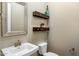 Powder room with a modern sink, floating wood shelves, and neutral color palette at 19575 E Vallejo St, Queen Creek, AZ 85142