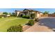Spacious single-story home with a well-manicured lawn and paver driveway leading to the garage at 19575 E Vallejo St, Queen Creek, AZ 85142
