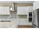 Modern kitchen with stainless steel appliances, granite countertops, tile backsplash, and white cabinetry at 19575 E Vallejo St, Queen Creek, AZ 85142