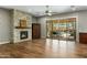 Cozy living room with stone fireplace, wood floors, and sliding glass doors to backyard patio and pool at 19575 E Vallejo St, Queen Creek, AZ 85142