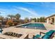 Backyard featuring a luxurious pool, beautiful landscaping, a built-in spa, and a fire pit at 19575 E Vallejo St, Queen Creek, AZ 85142