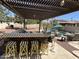 Outdoor kitchen and patio area with a built-in grill, bar seating, and view of a sparkling pool with mature landscaping at 4142 E Zion Pl, Chandler, AZ 85249