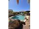 Resort-style pool with rock accents, palm trees, and a shaded patio area, perfect for outdoor living at 4142 E Zion Pl, Chandler, AZ 85249