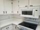 Kitchen features white cabinets, countertops, stainless steel microwave, and range at 17200 W Bell Rd # 1637, Surprise, AZ 85374