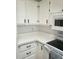 Kitchen featuring white cabinets, countertops, microwave, and a black stovetop at 17200 W Bell Rd # 1637, Surprise, AZ 85374