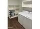 Bright laundry room with new appliances, shelves and wood-look floors at 19202 N Signal Butte Cir, Sun City, AZ 85373