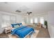 Bright bedroom with a large bed, white walls, multiple windows, ceiling fan, and colorful decor at 4306 E Tyson St, Gilbert, AZ 85295