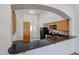 Open-concept kitchen features granite countertops, wood cabinetry, and black appliances at 4525 N 22Nd St # 404, Phoenix, AZ 85016