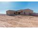 Front view of stucco home on desert lot at 23120 W Skinner Rd, Wittmann, AZ 85361
