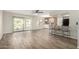Bright open-plan living room with wood-style flooring, white cabinets, and sliding glass doors to patio at 9502 W Mcrae Way, Peoria, AZ 85382