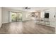 Bright open-plan living room with wood-style flooring, white cabinets, and sliding glass doors to patio at 9502 W Mcrae Way, Peoria, AZ 85382