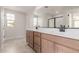 Bathroom featuring double sinks, undermount lighting, and a large mirror at 15598 S 181St Dr, Goodyear, AZ 85338