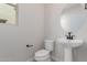 Powder bathroom featuring a modern pedestal sink, round mirror, and white toilet at 15598 S 181St Dr, Goodyear, AZ 85338