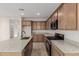 A view of a kitchen with wooden cabinets, granite countertops, and stainless steel appliances at 15598 S 181St Dr, Goodyear, AZ 85338