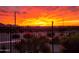 Stunning sunset view from the backyard, featuring a desert landscape and wrought iron fence at 35532 N Sunset Trl, San Tan Valley, AZ 85140