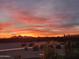 Backyard view showcasing a beautiful sunset over mountains and desert landscaping at 35532 N Sunset Trl, San Tan Valley, AZ 85140