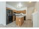 Kitchen features wood cabinets, granite island, and black appliances at 1718 W Colter St # 195, Phoenix, AZ 85015