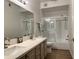 Bright bathroom featuring double sinks, white countertops, and a glass-enclosed shower/tub combo at 9455 E Raintree Dr # 1026, Scottsdale, AZ 85260