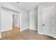 Spacious room with wood-look floors, neutral paint, a doorway, and a white six-panel door at 14189 W Sand Hills Rd, Surprise, AZ 85387