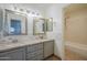 Bathroom featuring dual vanities with granite countertops and tiled shower at 5249 E Hobart St, Mesa, AZ 85205