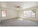 Light-filled bedroom with carpet, ceiling fan, and views of the pool and backyard at 5249 E Hobart St, Mesa, AZ 85205