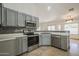 Bright kitchen with gray cabinets, stainless steel appliances, and mosaic tile backsplash at 5249 E Hobart St, Mesa, AZ 85205