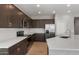 Modern kitchen with dark cabinetry, white subway tile backsplash, and stainless steel appliances at 17825 W Encinas Ln, Goodyear, AZ 85338