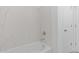 Bathroom featuring a white bathtub with marble-look tile and a door to a closet at 7620 W Minton St, Laveen, AZ 85339