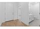 Hallway with wood flooring and a view of a well-lit bathroom with tile floors at 7620 W Minton St, Laveen, AZ 85339