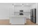 Bright, spacious kitchen features white cabinets, stainless steel appliances, and a center island at 7620 W Minton St, Laveen, AZ 85339