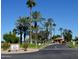Gated entrance to Happy Trails Resort, palm trees, and guardhouse at 17200 W Bell Rd # 1743, Surprise, AZ 85374