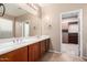 Bathroom featuring a double sink vanity, large mirror, and an attached walk-in closet at 2140 W Clearview Trl, Anthem, AZ 85086