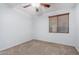 Clean, well-lit bedroom with a ceiling fan, window, and neutral-toned carpet at 2140 W Clearview Trl, Anthem, AZ 85086