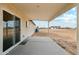 Covered back patio with sliding glass doors and views of the desert landscape at 31812 N 221St Dr, Wittmann, AZ 85361