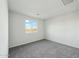 Bright bedroom with a window showcasing neighborhood views and neutral gray carpet at 31812 N 221St Dr, Wittmann, AZ 85361