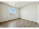 A bedroom features plank flooring, closet and view outside the window at 31812 N 221St Dr, Wittmann, AZ 85361