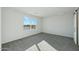 Bedroom with plush carpet, bright window, and a sliding barn door at 31812 N 221St Dr, Wittmann, AZ 85361