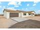 Inviting single-story home with neutral exterior, brown garage door, and well-lit entry showcases charm and curb appeal at 31812 N 221St Dr, Wittmann, AZ 85361