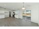 Open concept kitchen with stainless steel appliances, white cabinetry and wood-look flooring at 31812 N 221St Dr, Wittmann, AZ 85361