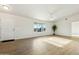 Bright living room featuring beautiful wood-look tile floors, abundant natural light, and a ceiling fan at 31812 N 221St Dr, Wittmann, AZ 85361