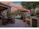 Outdoor kitchen and dining area with a pool in the background at 40903 N Harbour Town Way, Anthem, AZ 85086