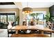 Dining room with natural light from the sliding glass door, rustic wood table, bench seating and modern light fixture at 40903 N Harbour Town Way, Anthem, AZ 85086