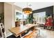 Dining room area with a rustic wood table, bench seating, modern lighting, and access to the backyard at 40903 N Harbour Town Way, Anthem, AZ 85086