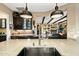 Modern kitchen with stainless steel sink, marble countertops, and industrial lighting at 40903 N Harbour Town Way, Anthem, AZ 85086